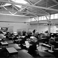 A black and white photograph of the Link Aviation factory floor with rows of trainers