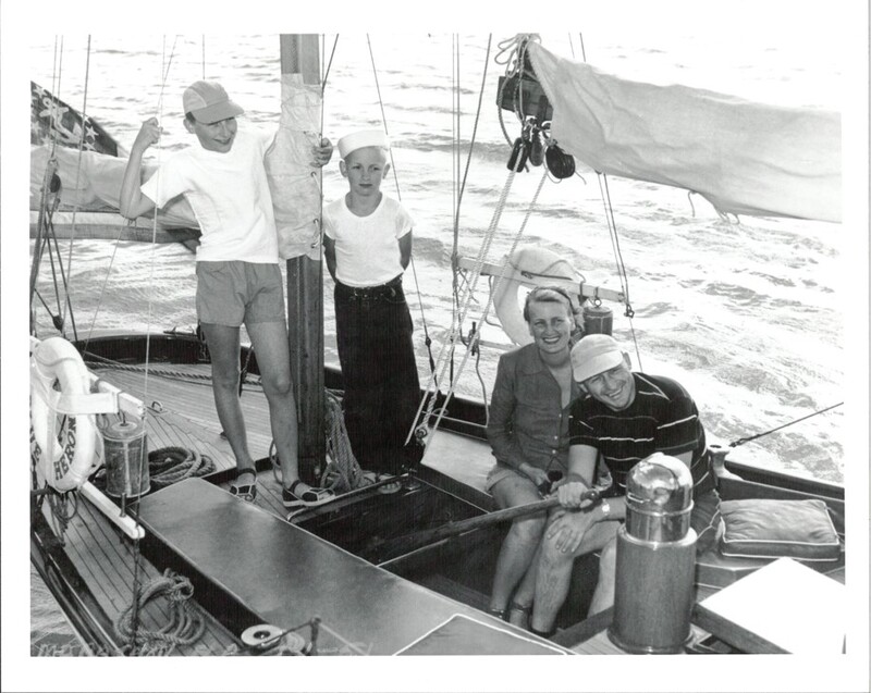 A black and white family photo of a couple and their two sons onboard the Blue Heron