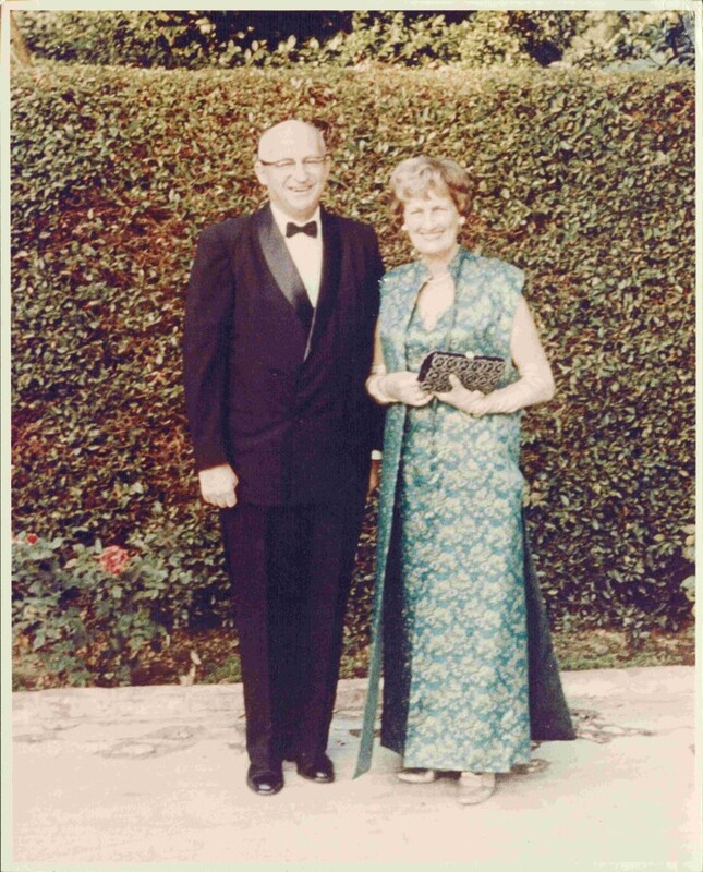 An old colored photograph of an elderly couple in formal attire