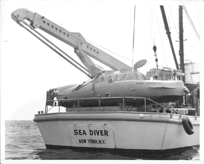 A black and white photograph of a submersible on a boat