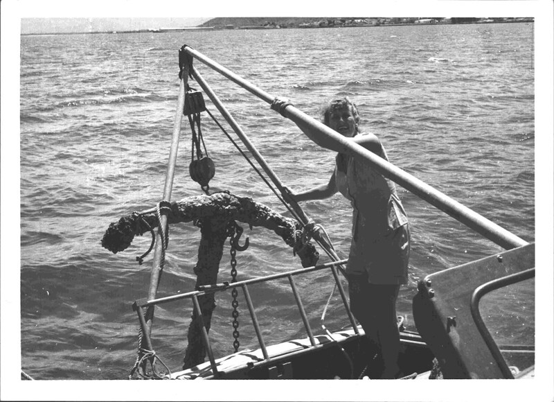 A black and white photograph of a woman with a rusted anchor