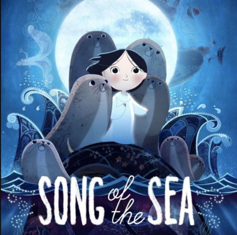 This image depicts Saoirse in the center, wearing a white night dress. She has short black hair and holds one arm out and the other at her chest. She is standing on a rock in the sea, surrounded by over five seals that stand with her on the rock. Around the rock are waves of the dark blue sea. The background is the night sky with a big, bright moon. On the bottom center of the image, the words "Song of the Sea" are written in white. 