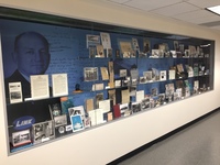 A collection of various photographs and documents on a wall display