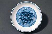 Chinese Ceramic Dish with a black dragon drawn in the center surrounded by blue waves