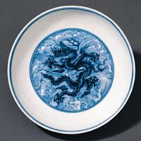 Chinese Ceramic Dish with a black dragon drawn in the center surrounded by blue waves